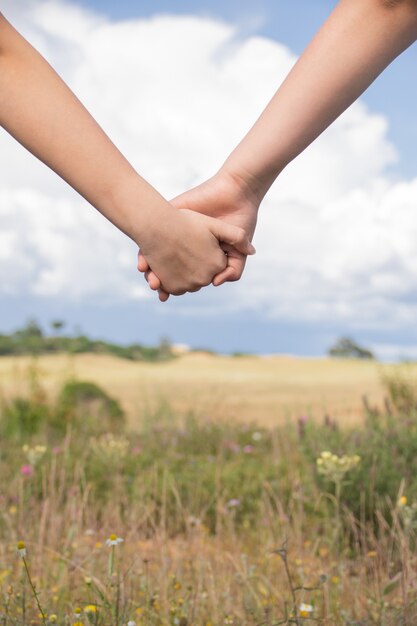 two people holdings hands together- friendship, love concepts
