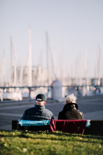 Free photo two people sitting on bench during daytime