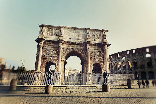 Two people standing on the colums near arch of Constantine