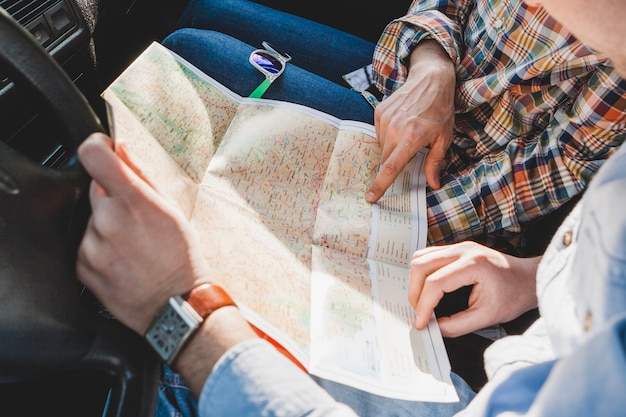 Two persons in car looking at map