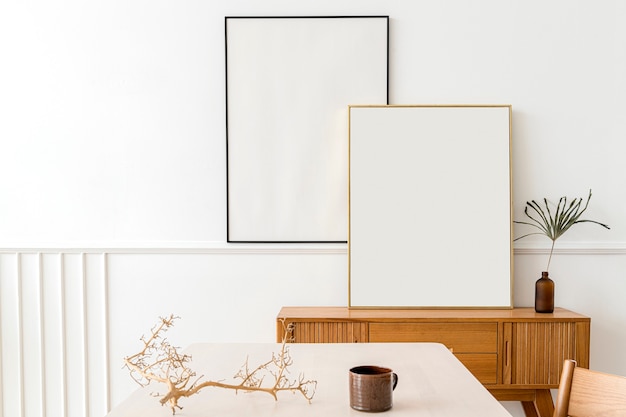 Two picture frames on a wooden sideboard