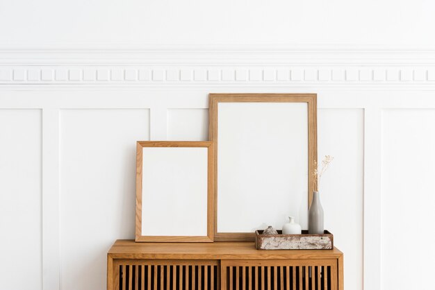 Two picture frames on a wooden sideboard