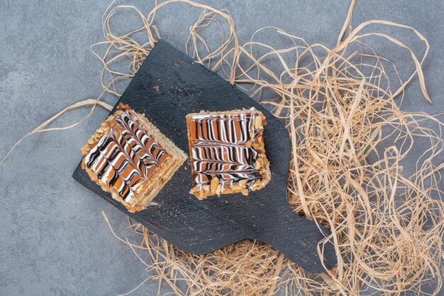 Two piece of cake on dark cutting board