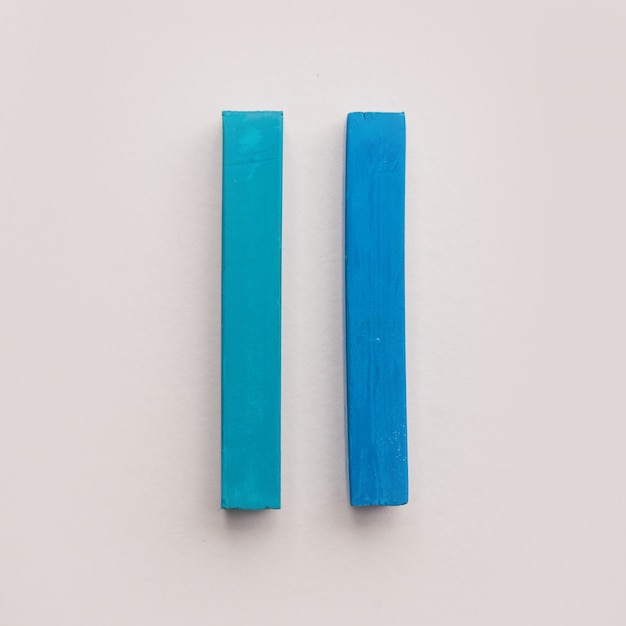 Free photo two pieces of blue pastel crayon chalks