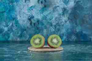 Free photo two pieces of kiwi on trivet, on the marble table.