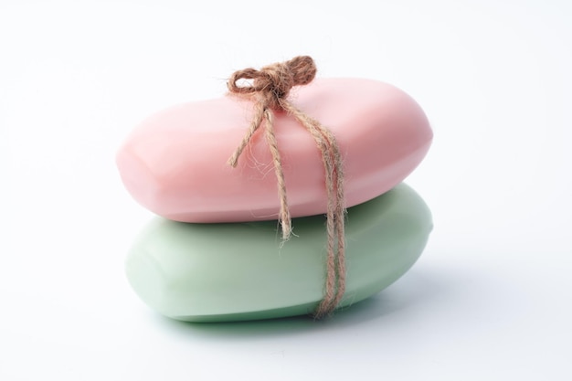 Two pieces of soap tied with a ribbon on a white background