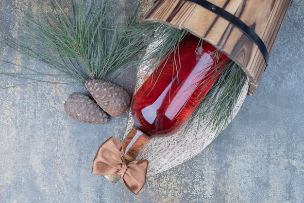 Two pinecones with bottle of wine on marble background. High quality photo