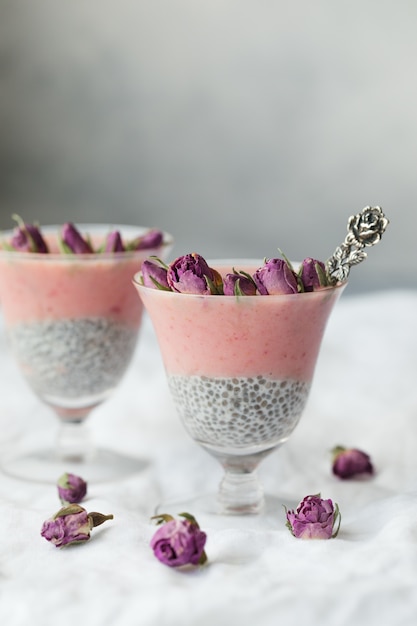 Two pink tapioca dessert topped with pink rose buds