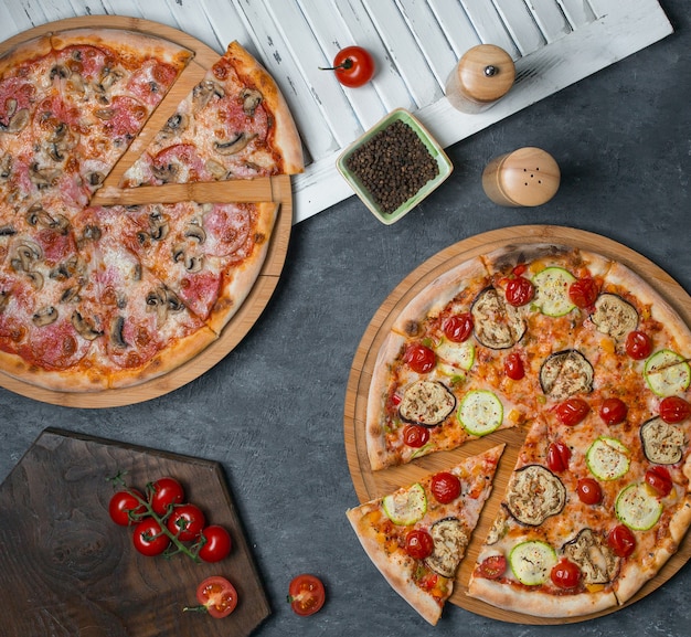 Two pizzas with mixed ingredients