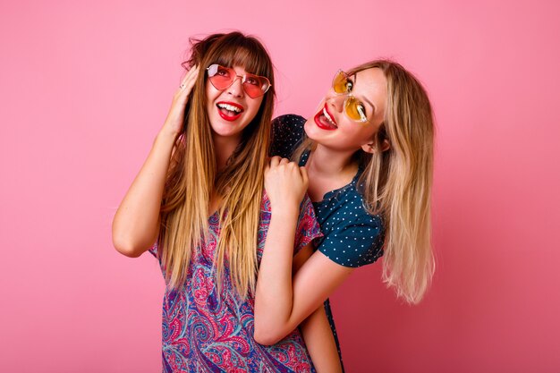 Two positive best friends having fun wearing sunglasses