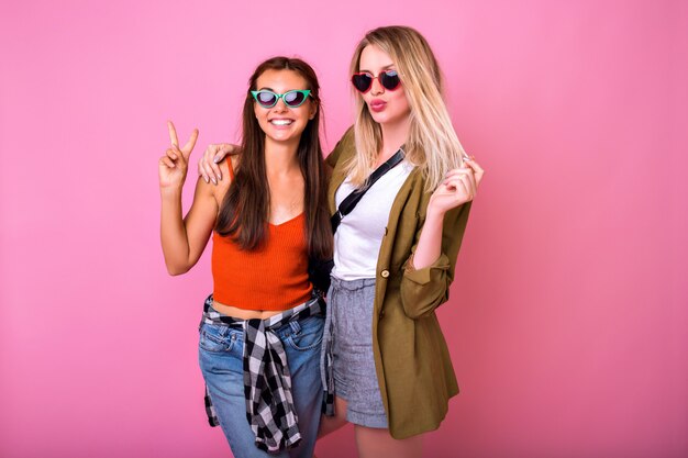 Two positive best friends having fun wearing sunglasses