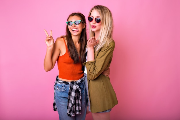 Two positive best friends having fun wearing sunglasses