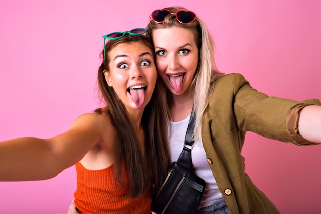 Two positive best friends having fun wearing sunglasses