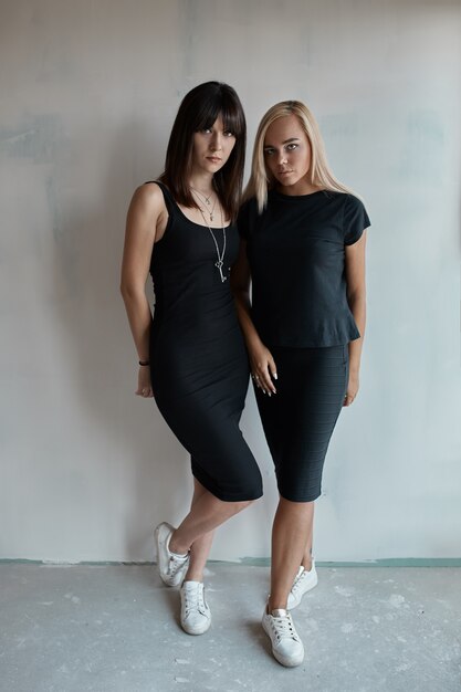 Две красивые женщины в черном платье в помещении