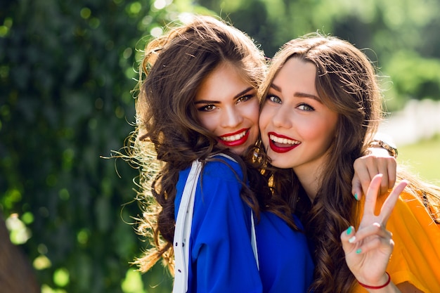 Free photo two pretty women hugging and smiling