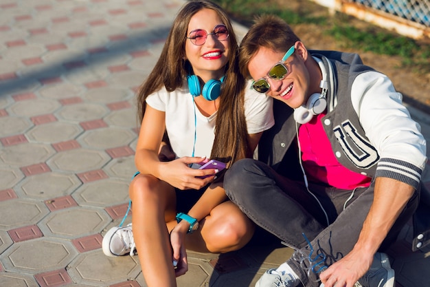 Two pretty young modern teenagers posing outdoor in stylish casual outfit