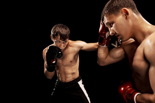 Free photo two professional boxer boxing on black space,