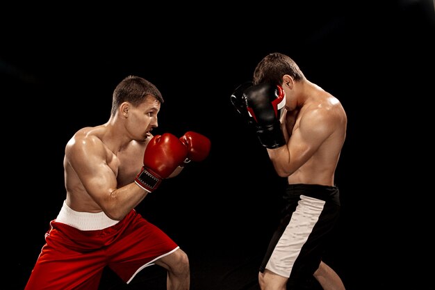 Two professional boxer boxing on black