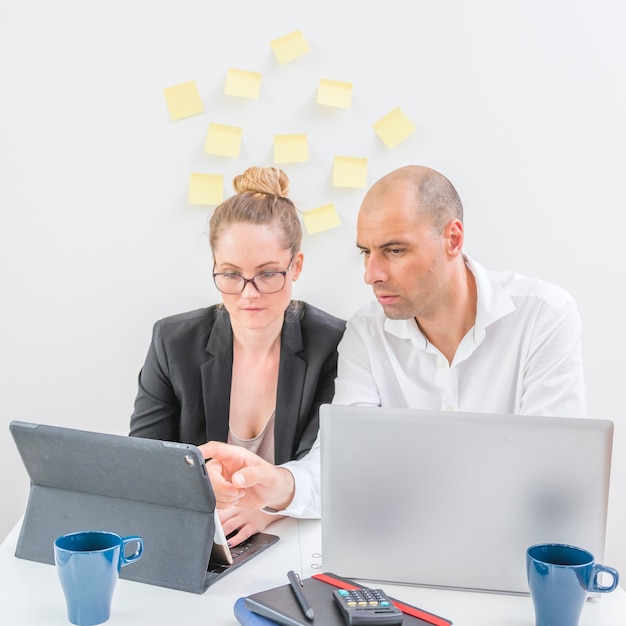 Two professional businesspeople working on laptop in office