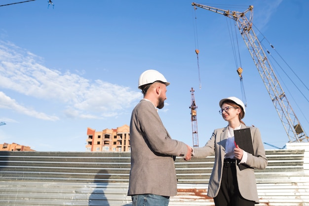 Free photo two professional engineer shaking hand at construction site