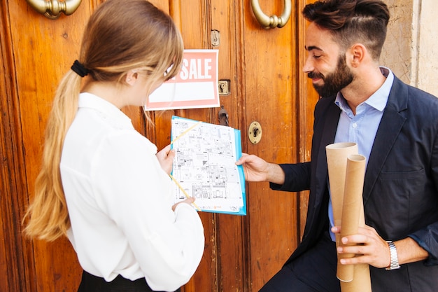 Free photo two real estate agents in front of a door