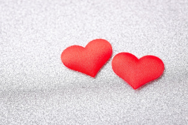 Two red hearts on silver background