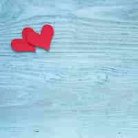 Free photo two red hearts on wooden table