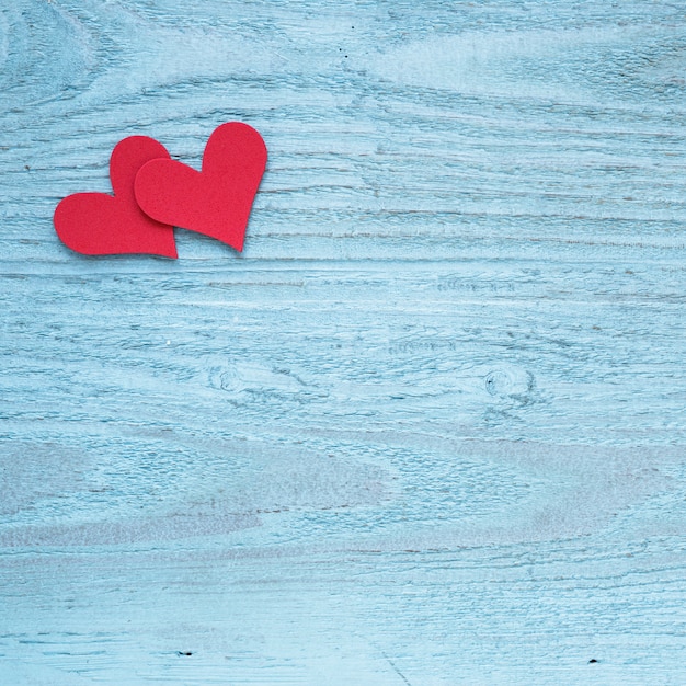 Two red hearts on wooden table