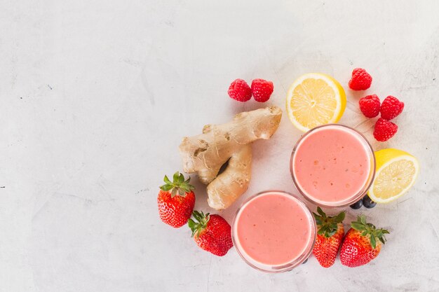 Two red smoothies with strawberries and ginger