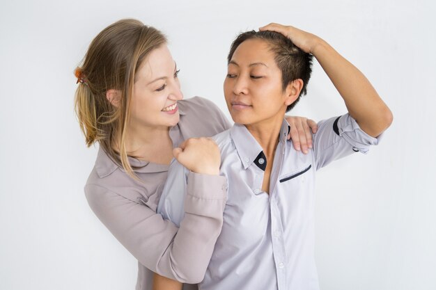 Two relaxed women hugging and looking at each other