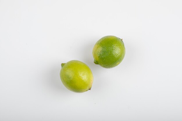 Two ripe lime fruits isolated on white.