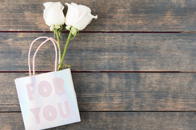 Free photo two roses in paper bag with for you inscription