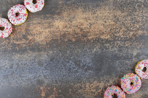 Two rows of bite-sized donuts on wooden surface