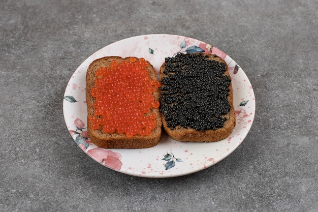 Foto gratuita due fette di pane di segale con caviale fresco. vista dall'alto