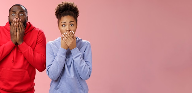 Free photo two shocked africanamerican man woman widen eyes concerned terribly sorry press palms mouth gasping