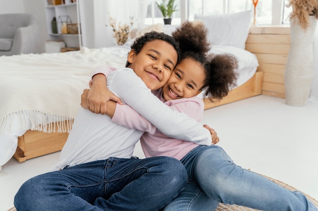 Free photo two siblings embracing each other at home