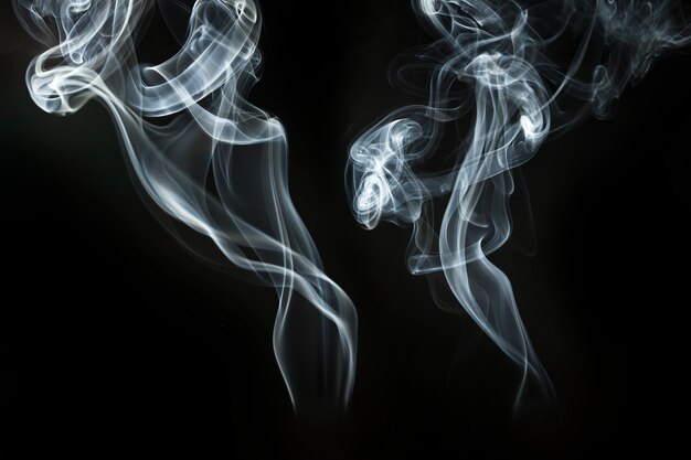 Two silhouettes of smoke on dark background