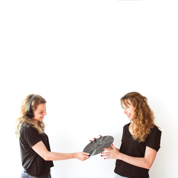 Two sister holding vinyl record isolated over white backdrop