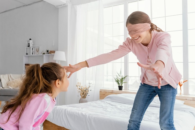 目隠しをしながら家で遊ぶ2人の姉妹