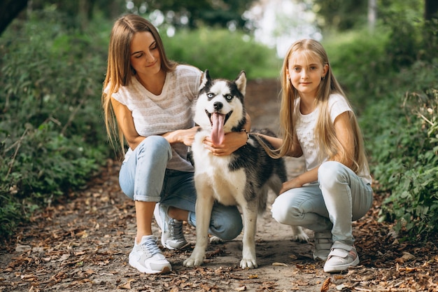Foto gratuita due sorelle con il loro cane nel parco
