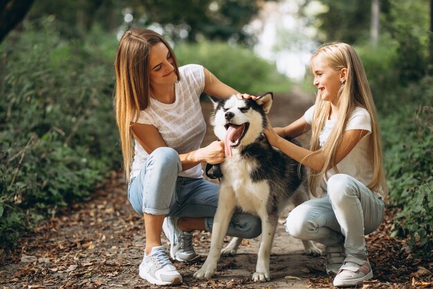 Two sisters with their dog in park