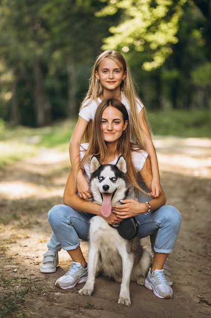 Two sisters with their dog in park