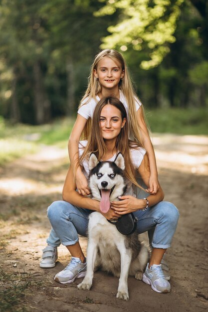 Two sisters with their dog in park