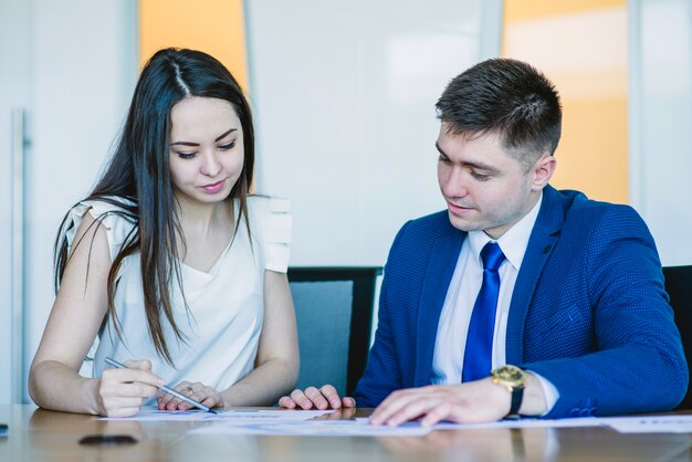 Two sitting business people looking at documents