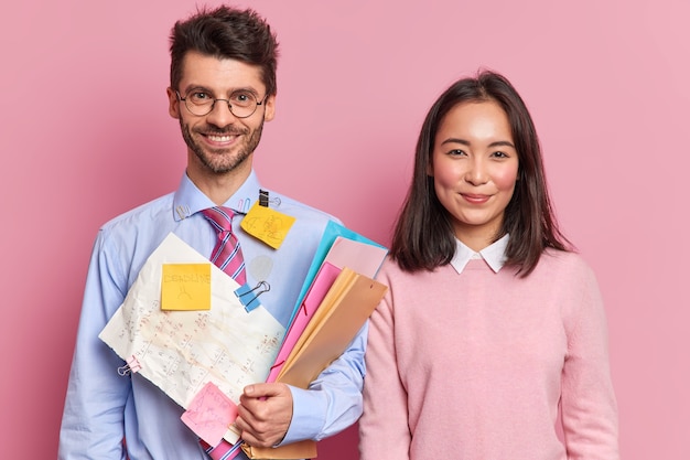 Two skilled diverse female and male students stand glad next to each other prepare scientific project together 