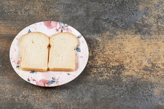 Foto gratuita due fette di pane sul piatto colorato.