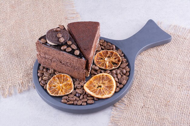 Due fette di torte al cioccolato con chicchi di caffè e fette d'arancia. foto di alta qualità