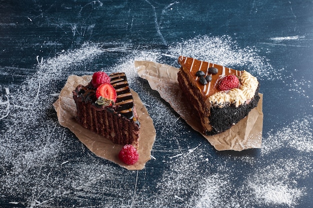 Two slices of chocolate and caramel cakes. 