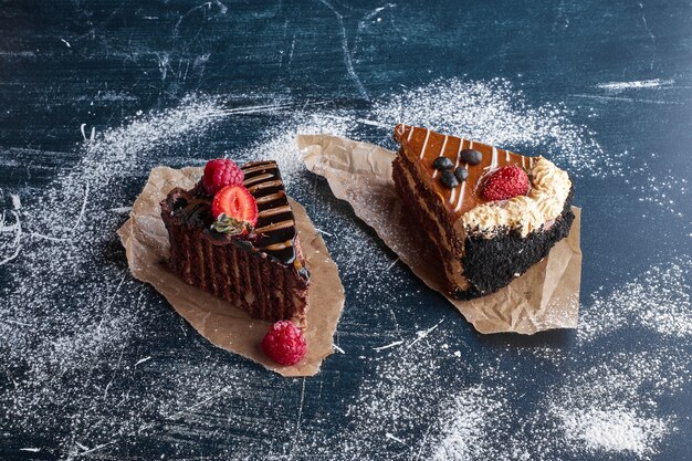 Two slices of chocolate and caramel cakes. 