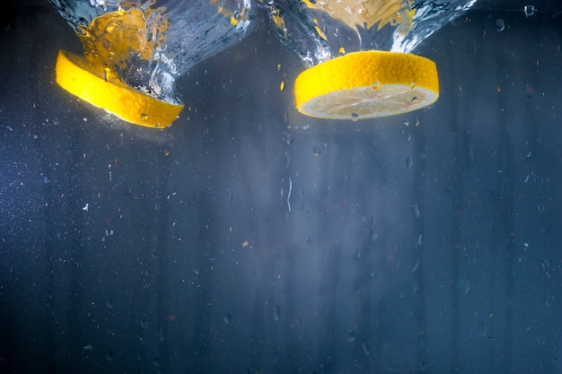 Free photo two slices of lemon in water